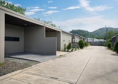 Modern exterior view of residential buildings with driveway and green landscaping.