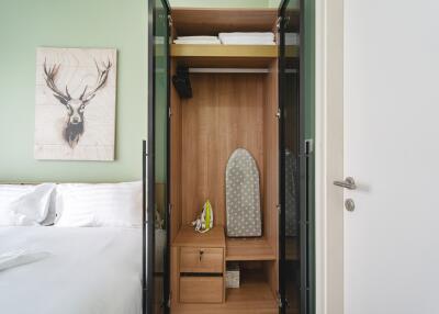 Open wardrobe in a bedroom with an ironing board inside