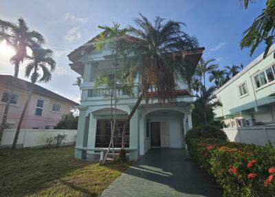 Exterior view of a two-story house with surrounding vegetation and driveway