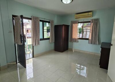 Empty bedroom with tiled floor, window, and closet