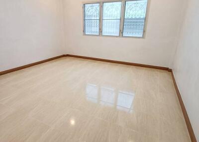 Spacious empty bedroom with tile flooring and windows