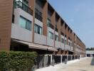 Exterior view of a multi-story residential building with multiple units and a gated entrance