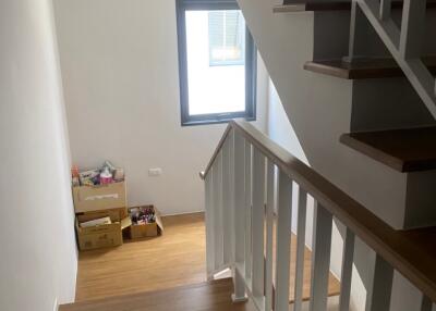 Internal staircase with wooden steps and white railing