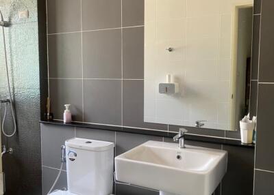 Modern bathroom with toilet, sink, and shower