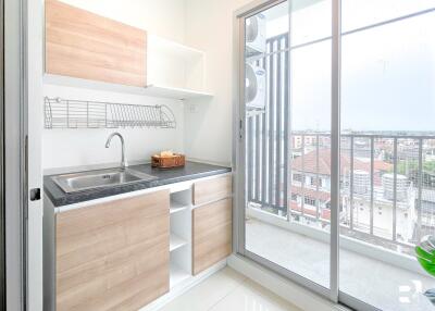 Modern kitchen with wooden cabinets and a balcony view