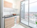 Modern kitchen with wooden cabinets and a balcony view