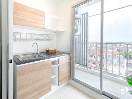 Modern kitchen with wooden cabinets and a balcony view