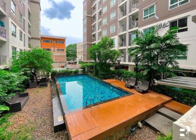 Swimming pool surrounded by residential buildings and greenery