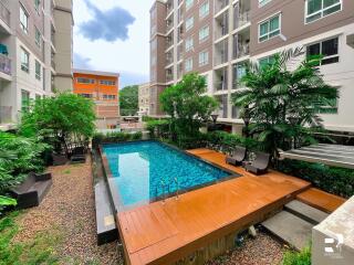 Swimming pool surrounded by residential buildings and greenery