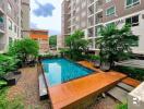 Swimming pool surrounded by residential buildings and greenery