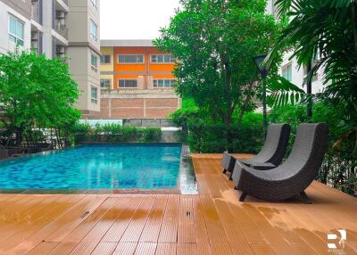 Outdoor swimming pool with deck chairs and surrounding greenery