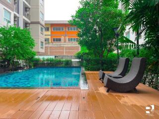 Outdoor swimming pool with deck chairs and surrounding greenery