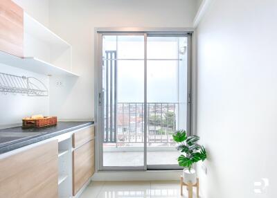 Modern kitchen area with large sliding glass door to balcony