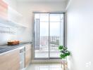 Modern kitchen area with large sliding glass door to balcony