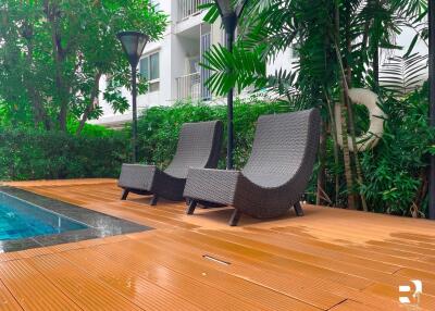 Outdoor seating area with lounge chairs near a pool