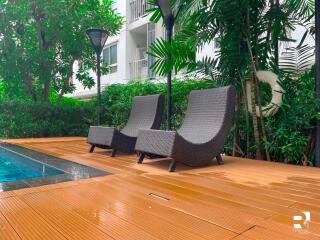 Outdoor seating area with lounge chairs near a pool