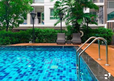 Swimming pool with lounge chairs and lush greenery