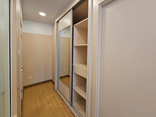 Spacious closet with wooden flooring and built-in storage