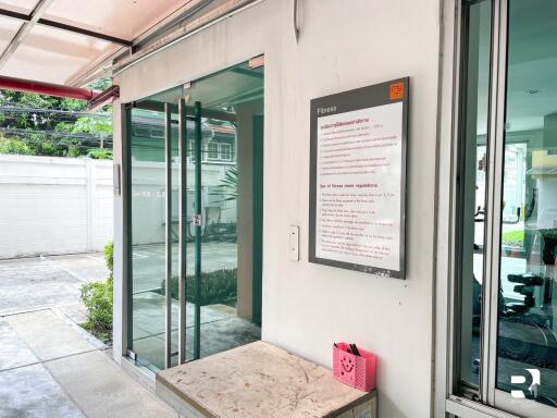 Gym entrance with glass doors and fitness sign