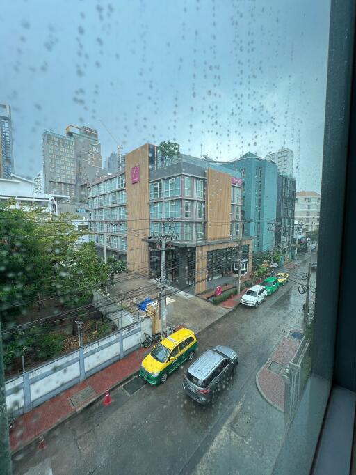 View of a rainy city street with buildings and cars from a window