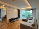 Spacious living room with large window and modern furniture.