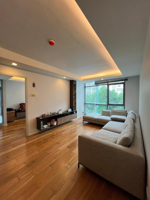 Spacious living room with large window and modern furniture.