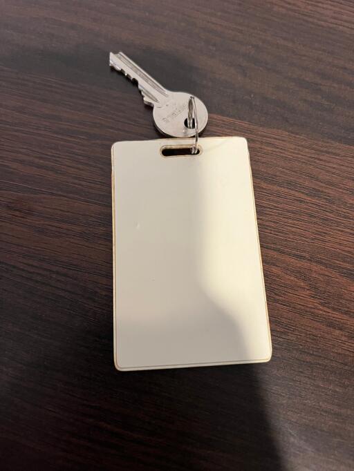 A Key with a Blank Keycard on a Wooden Surface