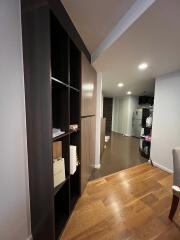 A well-lit hallway with wooden flooring and built-in cabinetry