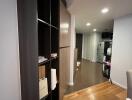 A well-lit hallway with wooden flooring and built-in cabinetry