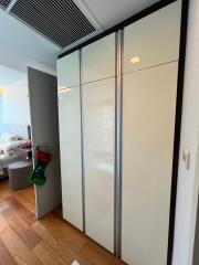 A modern bedroom with a large wardrobe and wooden flooring