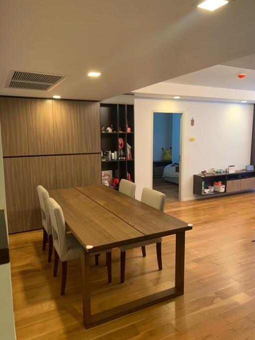 Modern dining area with wooden table and chairs, open to living space.