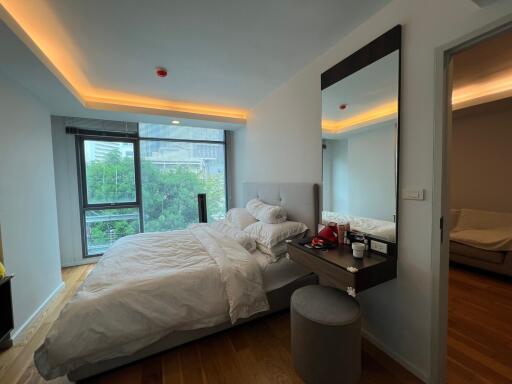 Modern bedroom with large window and wooden flooring