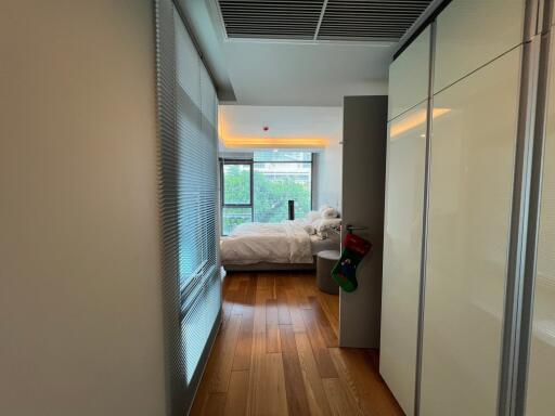 Modern bedroom with large windows and wooden flooring