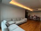 Spacious living room with grey sectional sofa and wooden flooring