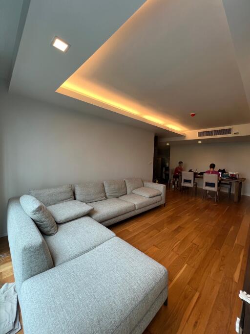 Spacious living room with grey sectional sofa and wooden flooring