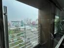 View from a balcony with glass railing overlooking cityscape