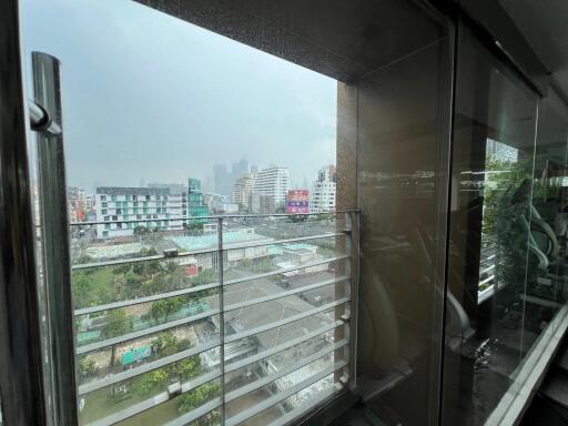 View from a balcony with glass railing overlooking cityscape