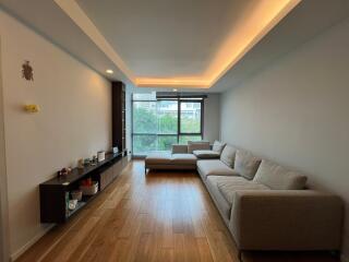 A modern living room with large windows and a comfortable sectional sofa.