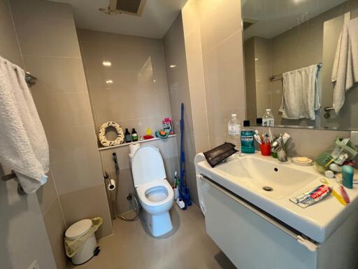 Bathroom with a toilet, sink, and mirror