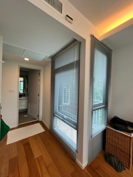 Modern hallway with wooden flooring and windows with blinds