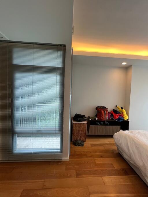 Modern bedroom with wooden floors and window blinds