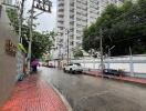 Tall residential building viewed from street level on a rainy day