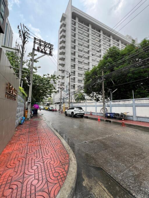 Tall residential building viewed from street level on a rainy day