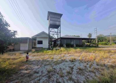 Exterior of a property with a tower and surrounding grassy yard