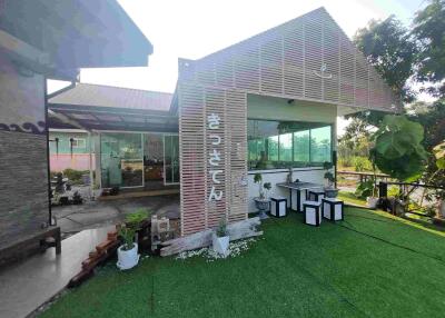 Outdoor view of a cafe or small building with greenery