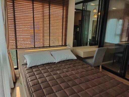 Cozy bedroom with large window and wooden blinds