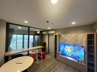 Modern living room with marble TV stand and large windows providing a view