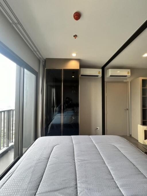 Bedroom with large window, mirrored closet, and air conditioning units