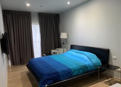 Modern bedroom with blue bedding and floor-to-ceiling curtains