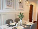 Modern dining area with table set for four, contemporary lighting, and framed artwork